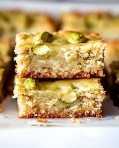 Full pistachio gooey butter cake in a pan with golden edges and green swirls.