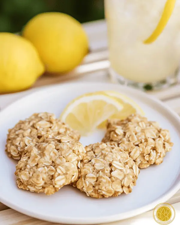 Lemon Oatmeal No Bake Cookies Recipe 4 Three lemon oatmeal no bake cookies served on white plate with glass of lemonade and fresh lemon garnish