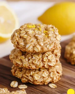 Stack of freshly made lemon oatmeal no bake cookies showing golden color and oat texture on wooden cutting board