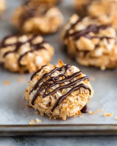 Close-up hero shot of no bake samoa cookies showing toasted coconut and chocolate drizzle details