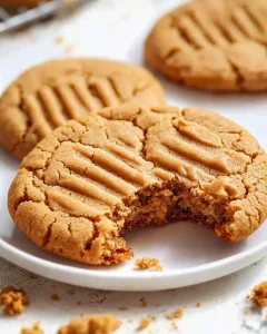 Perfect peanut butter cookies in the air fryer broken in half showing crispy exterior and gooey center