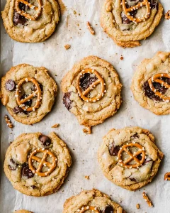 peanut butter cookies with pretzels on a baking tray, golden and fresh from the oven