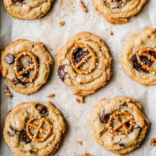 peanut butter cookies with pretzels on a baking tray, golden and fresh from the oven